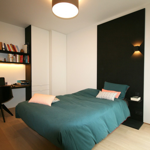 Door een zwarte MDF constructie te maken achter het bed wordt alle aandacht getrokken naar het bed. Dit zwarte accent trokken we verder door naar het bureau, opdat dit één geheel zou vormen. De witte slaapkamerkast gaat op in de achtergrond. Kast-ID Antwerpen